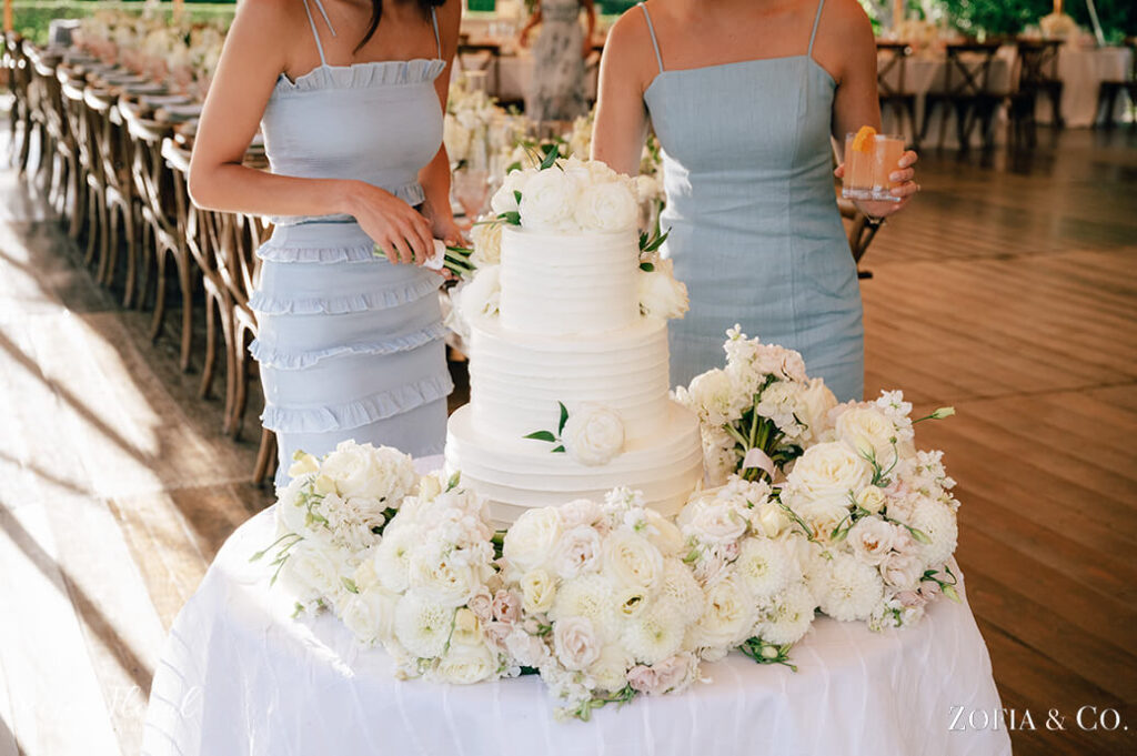 white tiered wedding cake with surrounding flowers