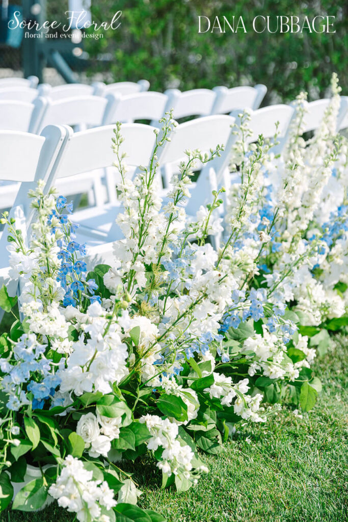 Blue & white floral hedges lining the wedding aisle